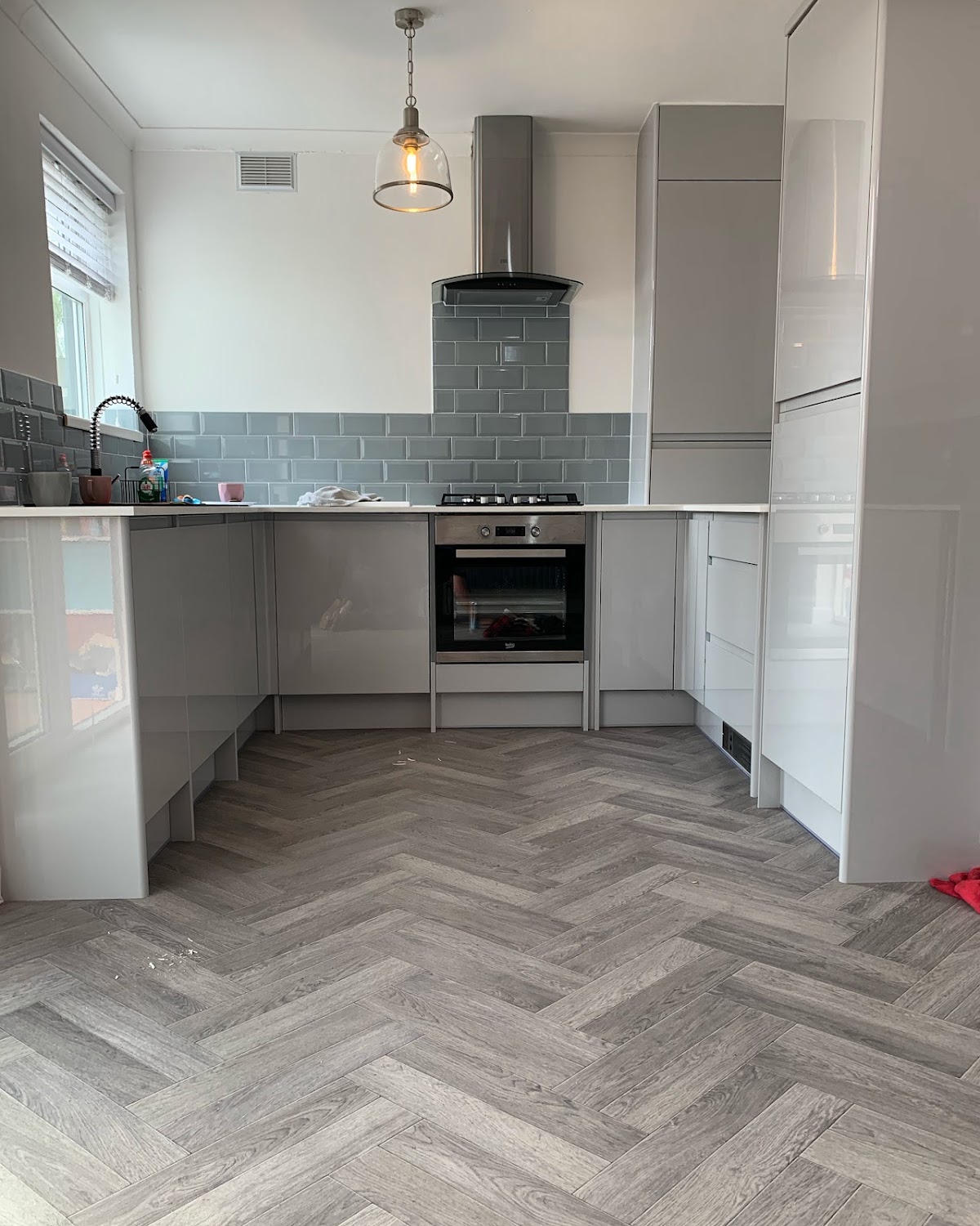 Grey herringbone LVT, gloss kitchen